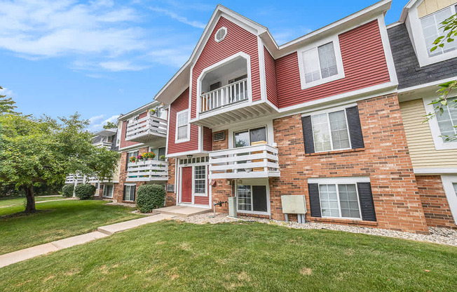 A red brick apartment building with a balconies on the second and third floors at Apple Ridge Apartments, Michigan, 49534