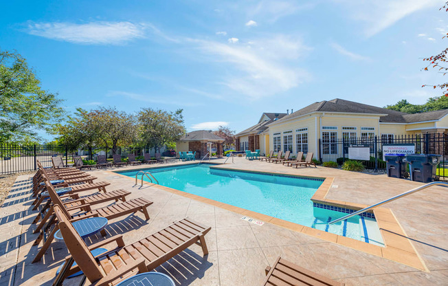 A sunny day at the pool with lounge chairs and a clear blue sky.