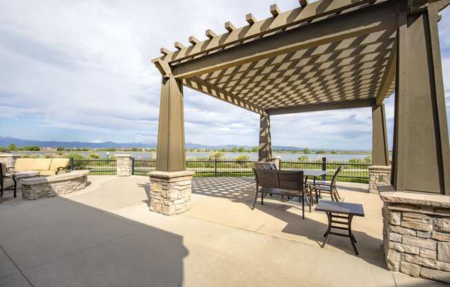 a patio with a pergola and a view of the water