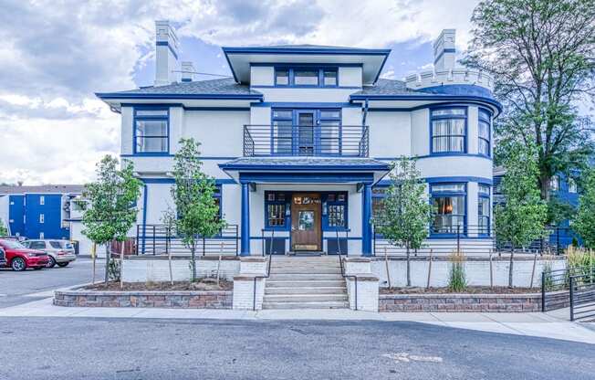 the front of a blue and white house with stairs