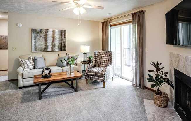 A living room with a couch, chair, and a fireplace.