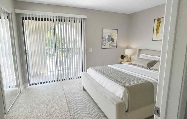 a bedroom with a bed and a sliding glass door