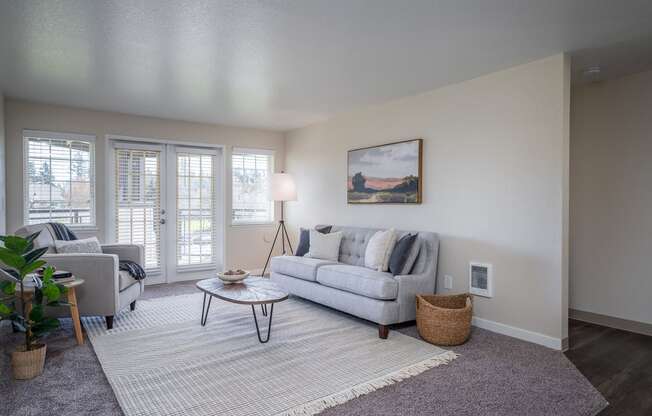 a living room with a couch and a chair and a window