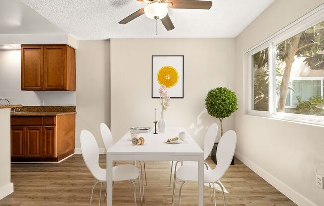 a dining room with a white table and chairs and a ceiling fan