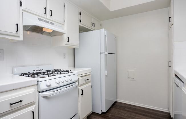 a kitchen with white appliances and white cabinets and a white refrigerator