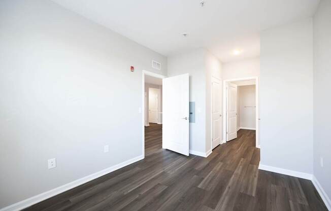 A room with wood flooring and white walls.