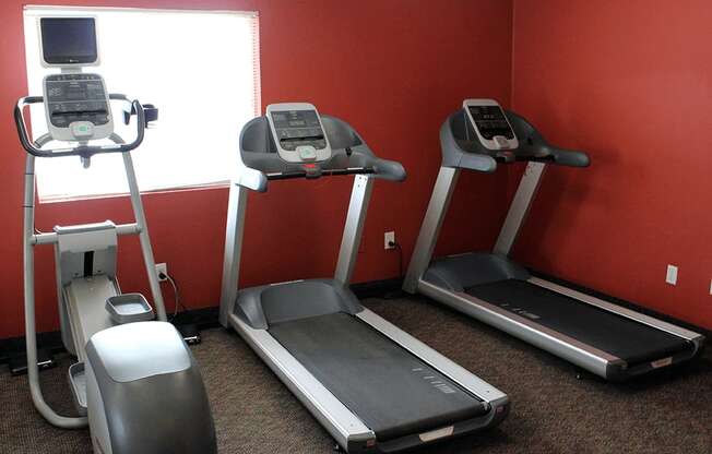 a gym with two treadmills and other exercise equipment at sun valley apartments