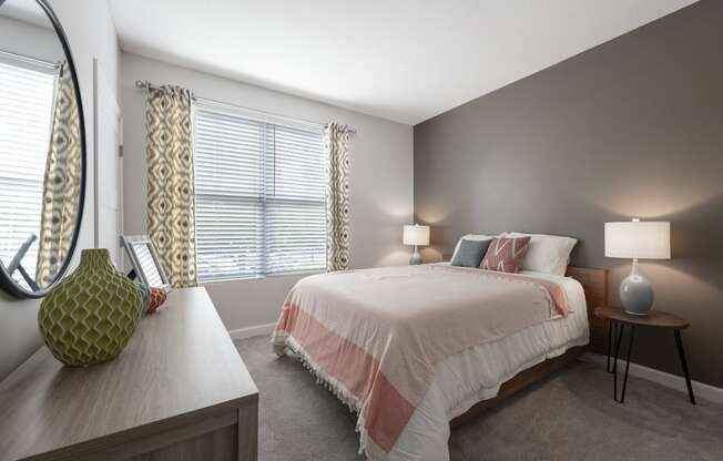 a bedroom with a bed and a dresser and a window