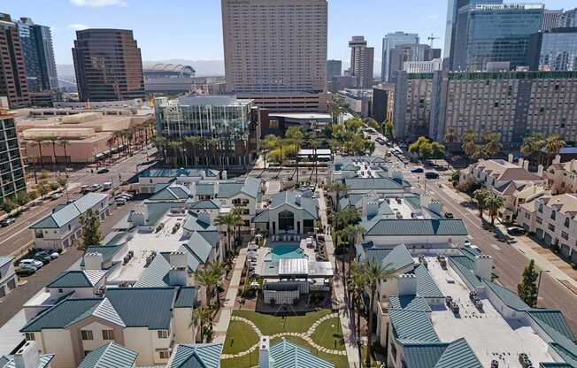 A view of a city with a lot of buildings and a green roofed building in the foreground.