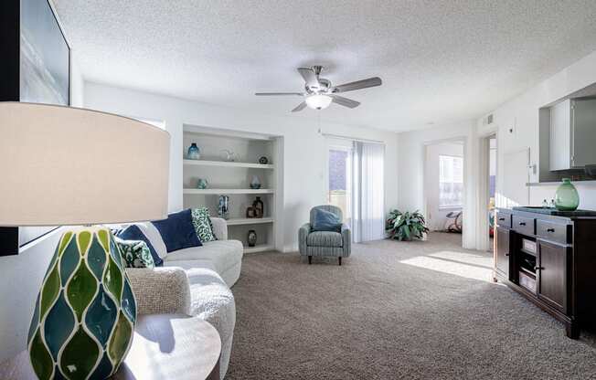 A cozy living space in the Skyler Ridge Apartments model unit with a couch and ceiling fan.