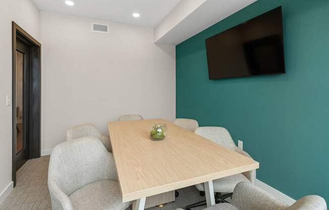 A conference room with a long table and chairs.