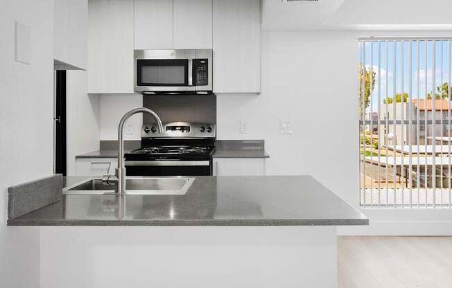 A modern kitchen with a stainless steel sink and countertop.