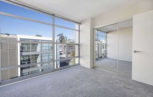 A room with a large window and a view of a building outside.