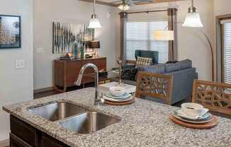 A kitchen with a granite countertop and a sink.