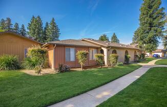 a large brick building with grass in front of a house