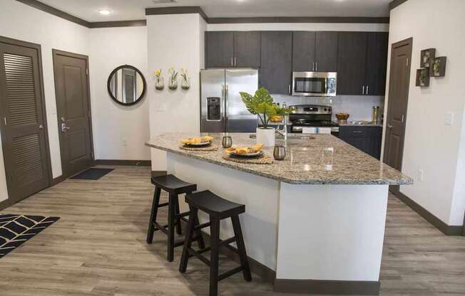 A kitchen with a bar stool in front of the island.