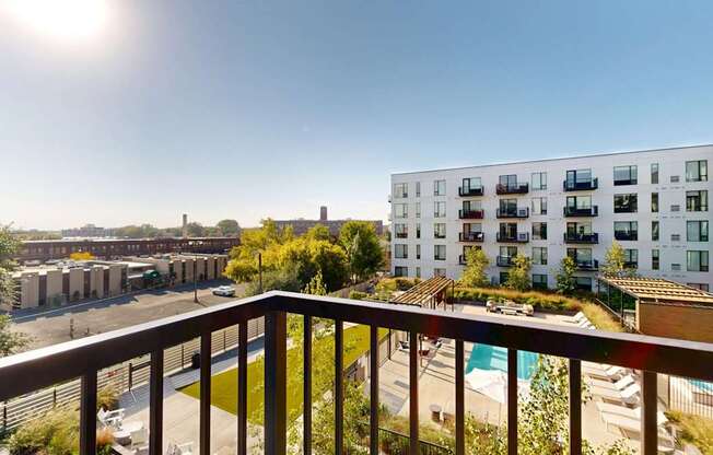 A sunny day at a residential complex with a pool and greenery.