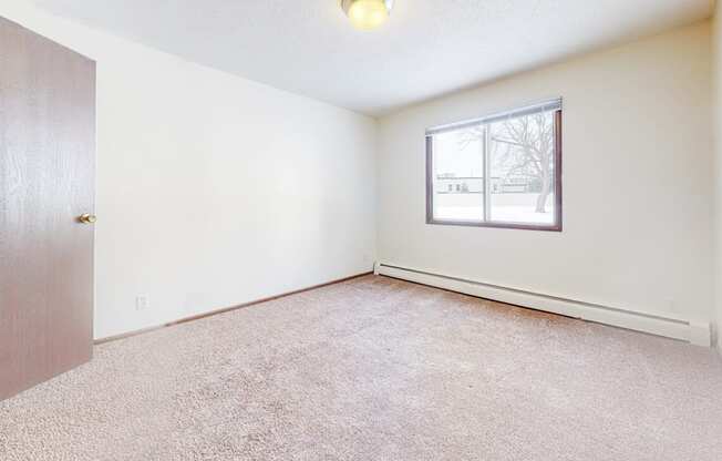 a bedroom with white walls and carpet