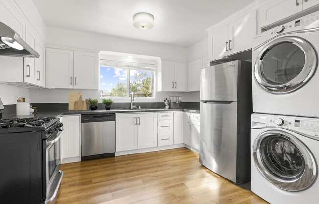 a kitchen with white cabinets and stainless steel appliances