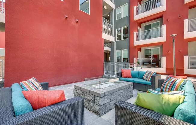 A patio with a table and chairs with colorful cushions.
