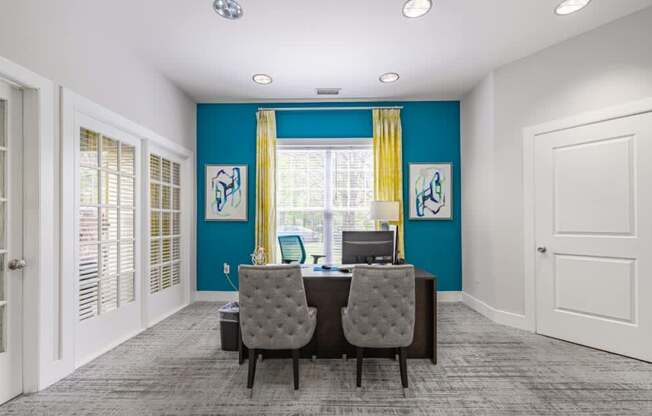 Two grey chairs are in front of a desk with a computer on it.