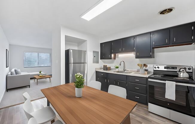 a kitchen and dining room with black cabinets and a wooden table