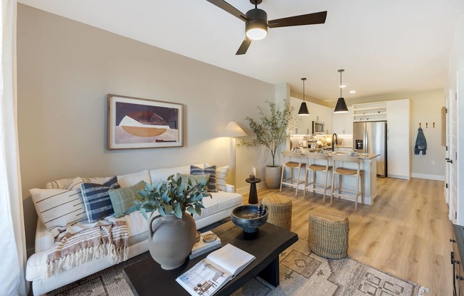 a living room with a couch and a table in front of a kitchen