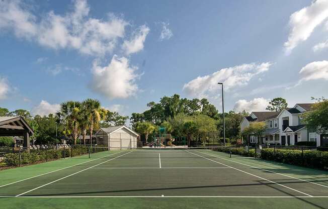 a tennis court at the resort with palm trees