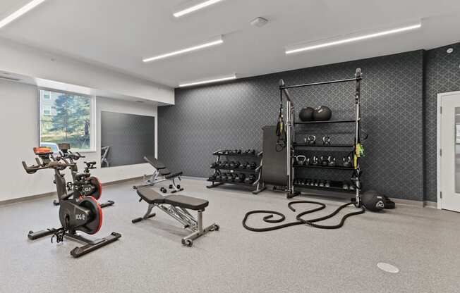 a spacious fitness center with exercise equipment and weights