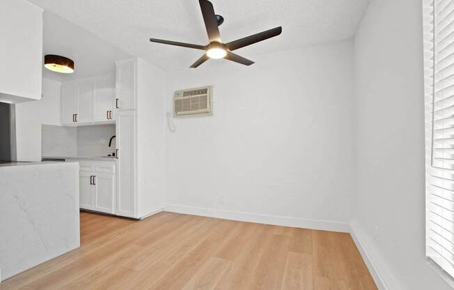 A room with a ceiling fan and a wall-mounted air conditioner unit.