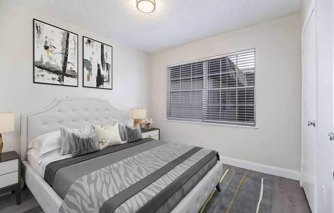 a white bedroom with a large bed and windows