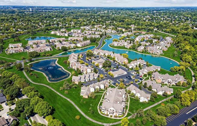 A bird's eye view of a residential neighborhood with a large swimming pool.