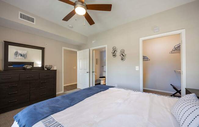 A bedroom with a large bed and a ceiling fan.