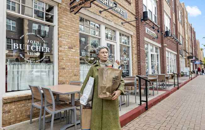 a woman standing on a sidewalk in front of a brick building