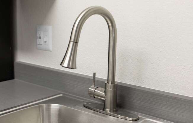 A modern kitchen sink with a chrome faucet.