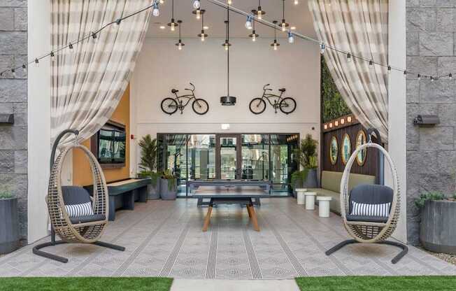 A modern outdoor seating area with wicker chairs and a bench.