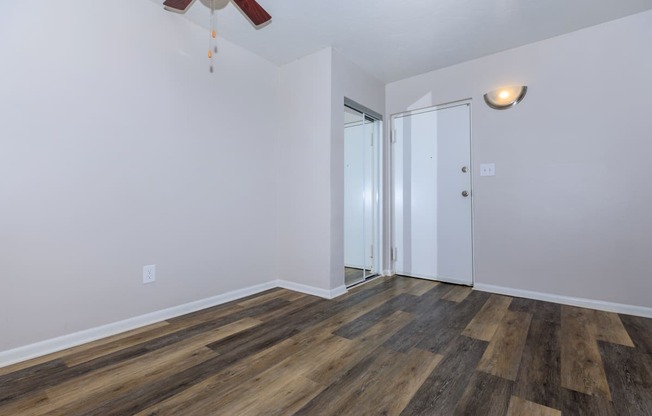 a bedroom with hardwood flooring and a ceiling fan