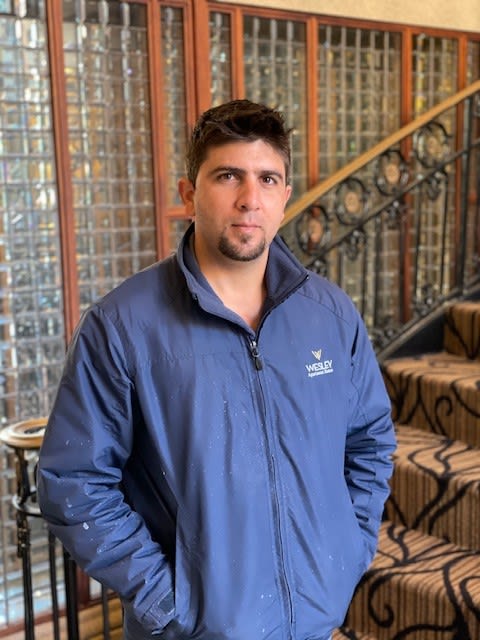 a man in a blue jacket standing next to a staircase