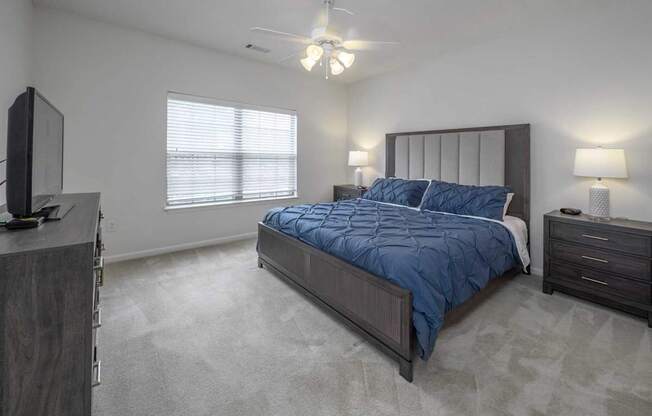 A bedroom with a bed, dresser, and television.