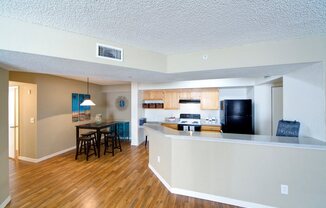 A kitchen with a bar and a dining table.