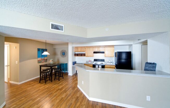 A kitchen with a bar and a dining table.
