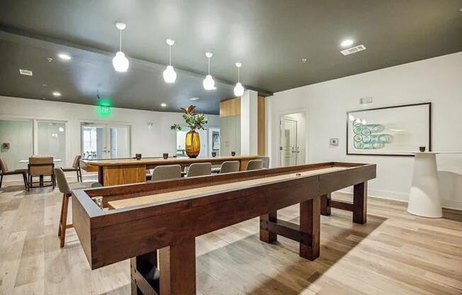 A pool table is in the middle of a room with a wooden floor.