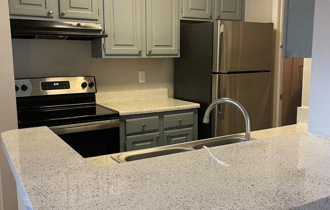 a kitchen with granite counter tops and stainless steel appliances at Aqua Bay Apartments in Naples, FL 34116