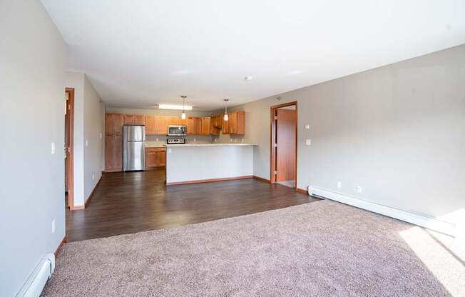 A kitchen with wooden cabinets and a refrigerator is visible. Fargo, ND Urban Plains Apartments