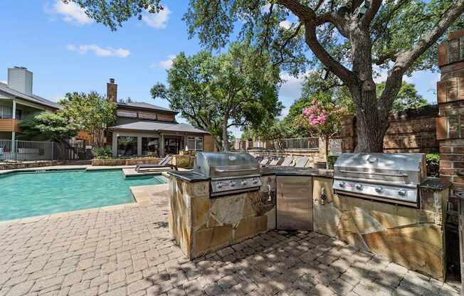 A backyard with a grill and a pool.