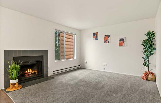 A living room with a fireplace and a grey carpet.