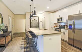 A kitchen with a white island and stainless steel appliances.