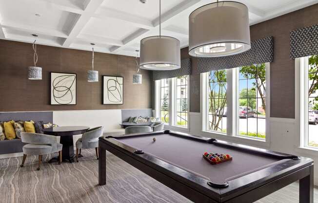 a recreation room with a pool table and chairs