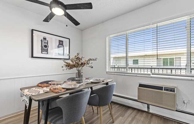 a dining room with a table and chairs and a ceiling fan