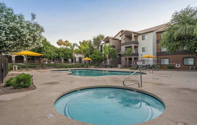 A swimming pool surrounded by a concrete patio and apartment buildings at Sterling Point Apartment Homes, Phoenix